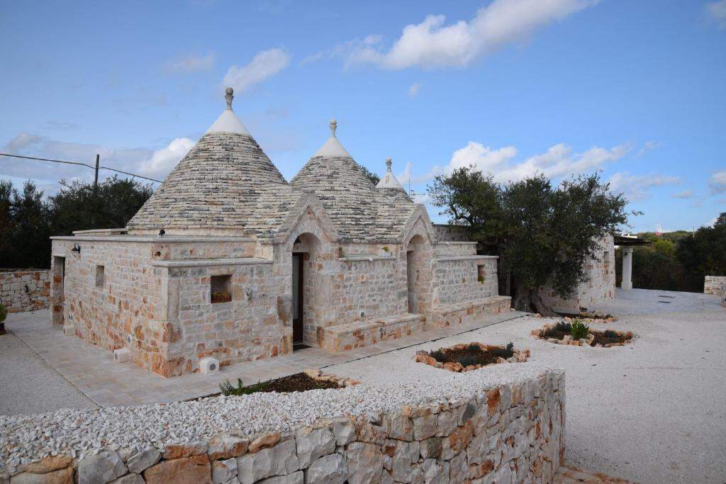 Restored trulli with stone roofs under a blue sky in Castellana Grotte
