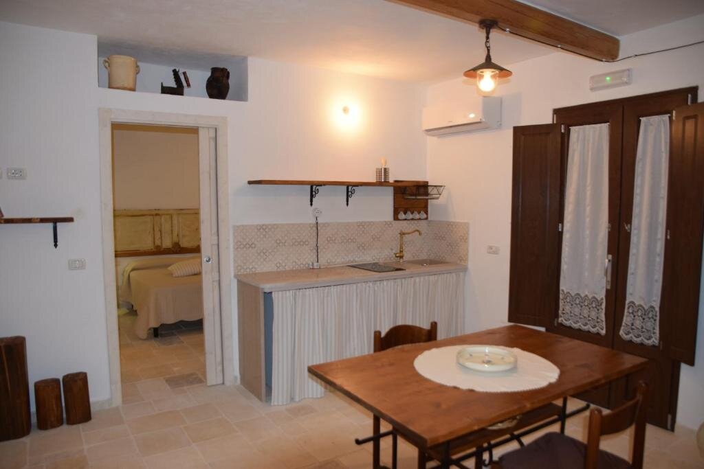 Kitchenette with dining table inside a restored trullo unit